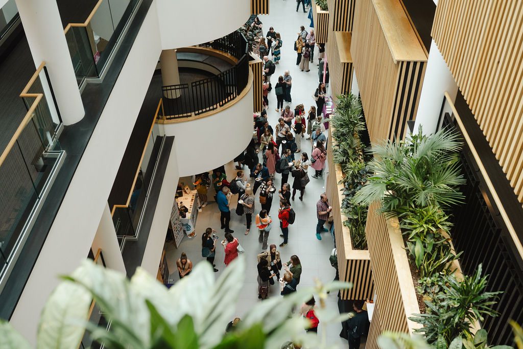 a birdseye view of an delegates at a EAUC conference with green plants and bamboo wood in the foreground